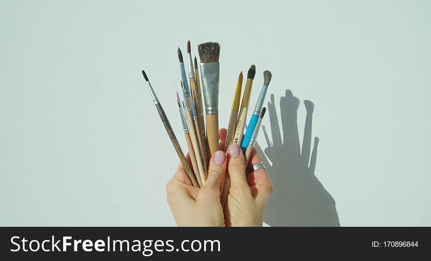 Paint brushes in the hand of painter.