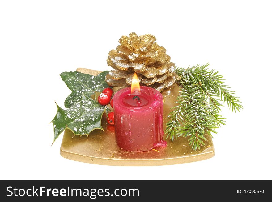 Christmas table decoration snow dusted seasonal foliage with a burning candle on a gold dish