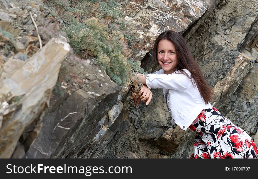 Happy young woman leaning against the rock. Happy young woman leaning against the rock