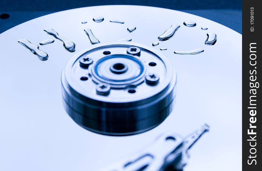 Closeup of read/write head of a computer hard drive and the word formed from water drops. Closeup of read/write head of a computer hard drive and the word formed from water drops.