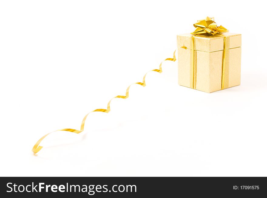 Christmas golden gift-box on white background, with long golden ribbon. Christmas golden gift-box on white background, with long golden ribbon
