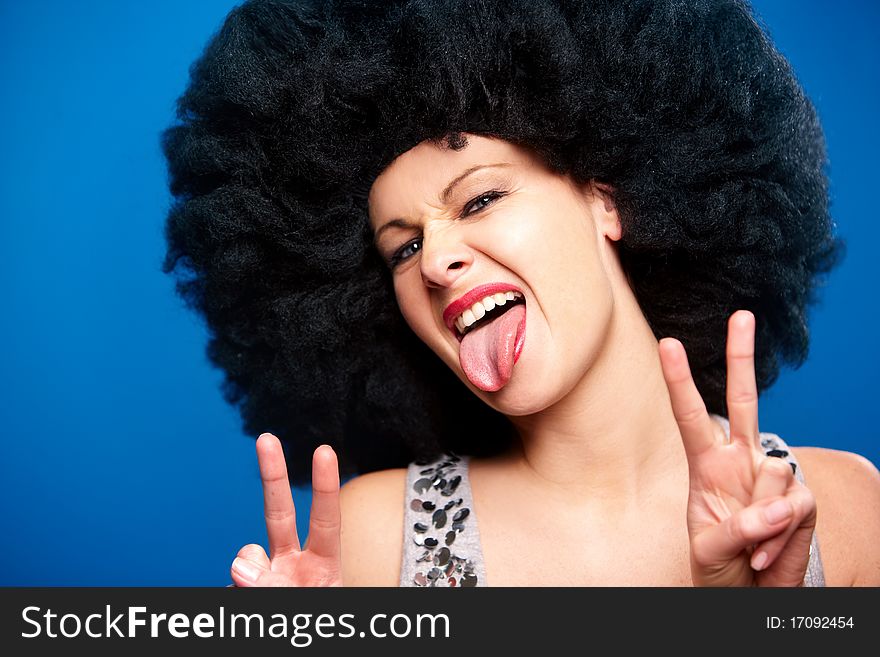 Portrait of a beautiful woman with huge afro haircut isolated on blue