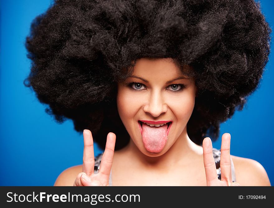 Portrait of a beautiful woman with huge afro haircut isolated on blue