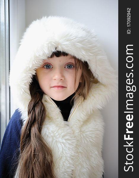 Adorable small girl in white fur hood