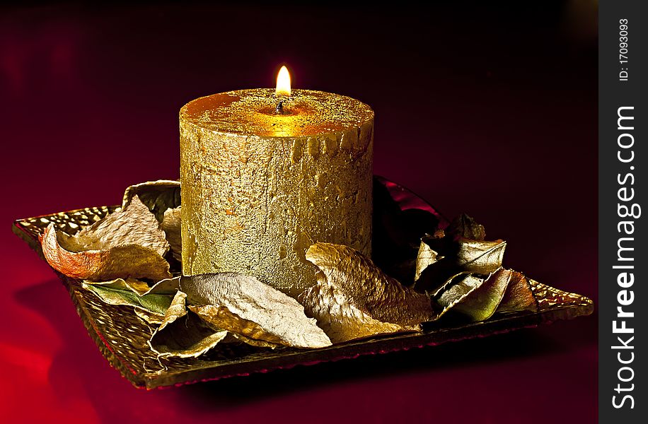 Richly decorated Christmas candle on the golden dish of golden petals ornament. Richly decorated Christmas candle on the golden dish of golden petals ornament.