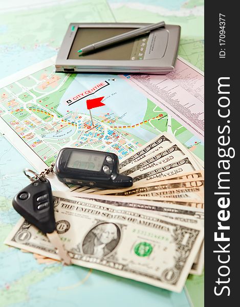 Road map with a red flag, car keys, electronic organizer and money. closeup. Road map with a red flag, car keys, electronic organizer and money. closeup.