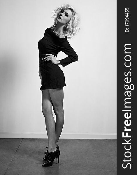 Leggy blond is posing in the short black dress. Leggy blond is posing in the short black dress