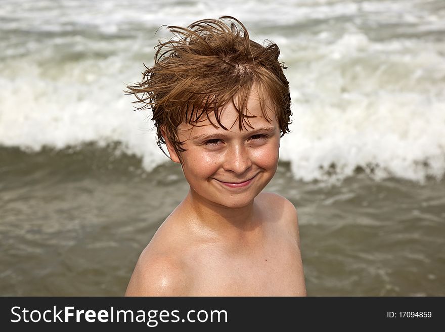 Boy enyoys the warm water in the ocean and smiles happy. Boy enyoys the warm water in the ocean and smiles happy