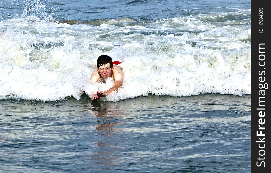 Young boy is body surfing in the waves