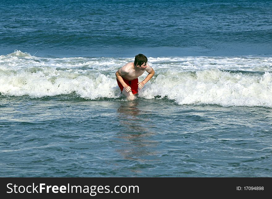 Young boy is body surfing in the waves