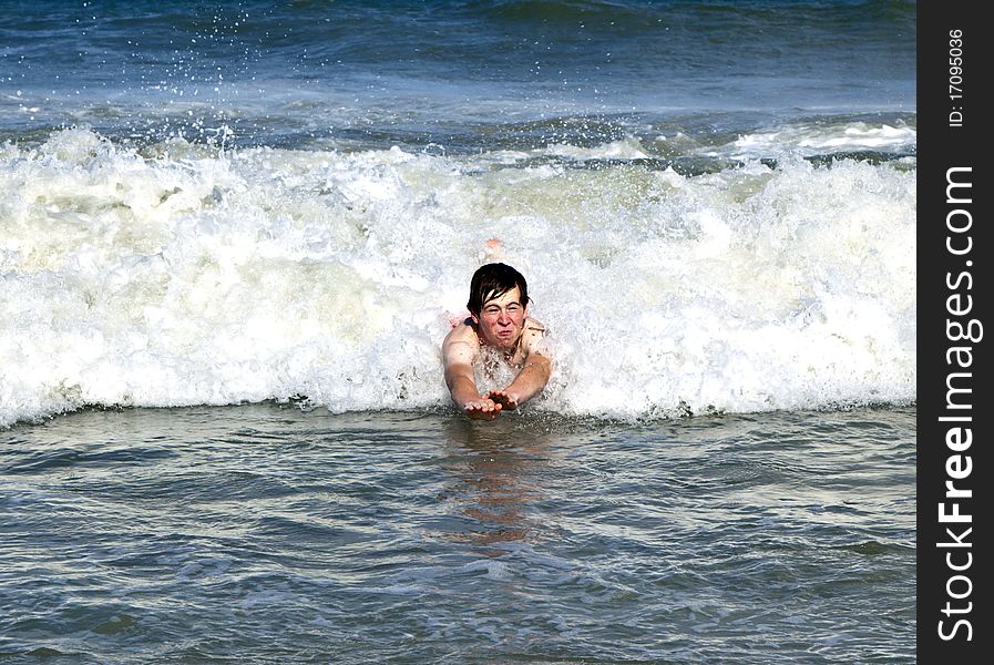 Young boy is body surfing in the waves