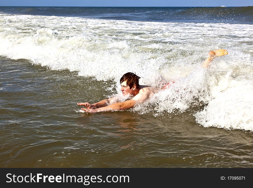 Young boy is body surfing in the waves