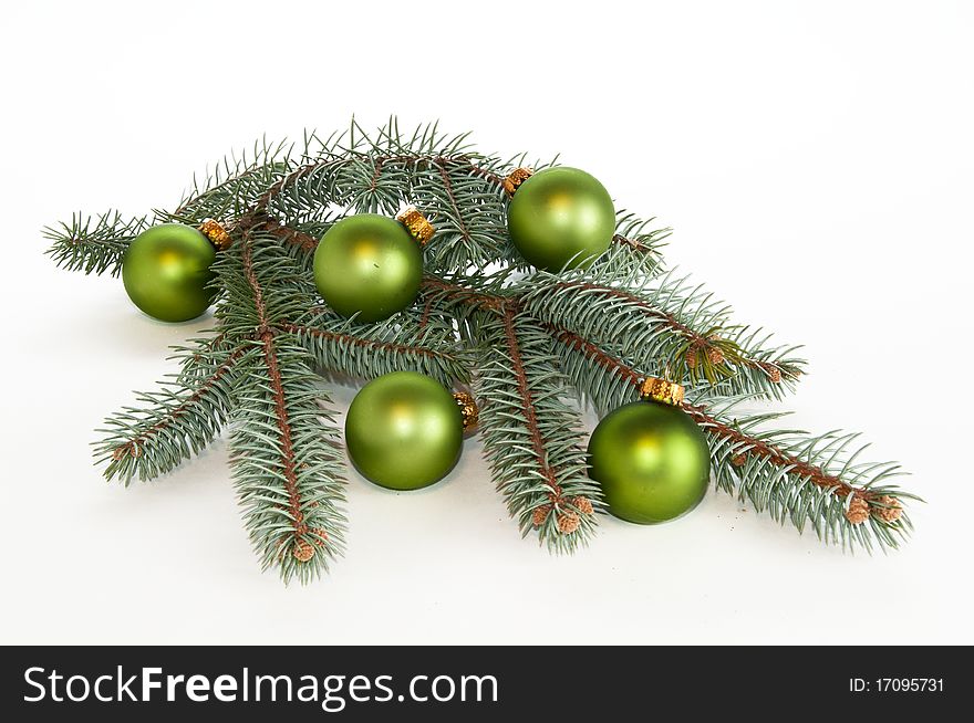 Center piece made of single branch of evergreen decorated with green ornaments on white, isolating background. Center piece made of single branch of evergreen decorated with green ornaments on white, isolating background