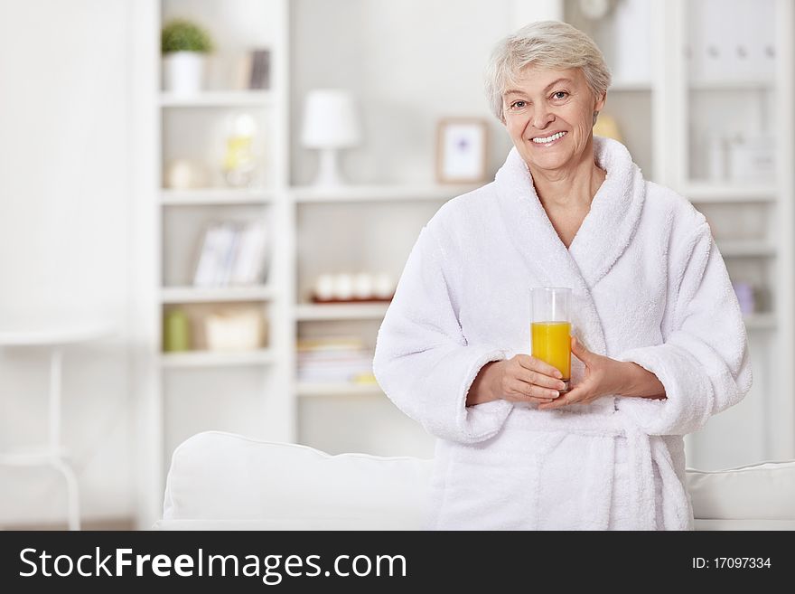 Attractive woman in a bathrobe with a glass of juice. Attractive woman in a bathrobe with a glass of juice