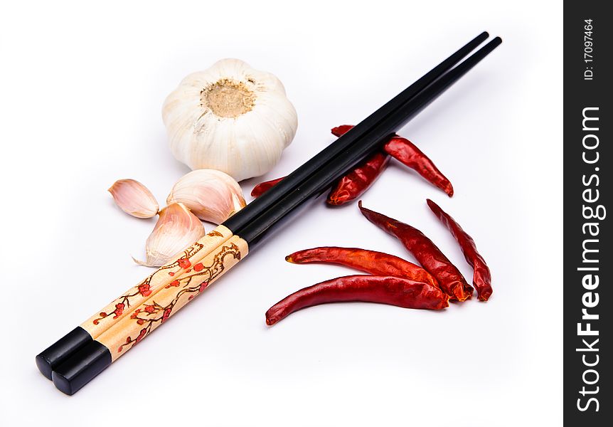 Chop sticks, chili fruit and garlic on a white background