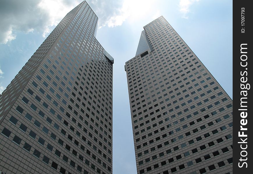 Two tall modern buildings soaring to a cloudy sky. Two tall modern buildings soaring to a cloudy sky.