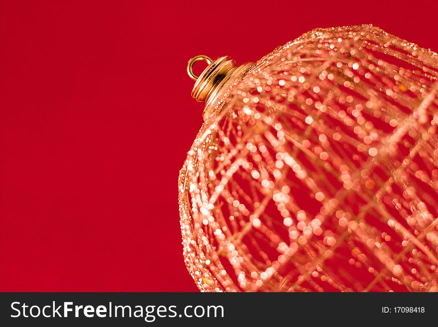 Golden christmas-tree decoration close-up over red. Golden christmas-tree decoration close-up over red