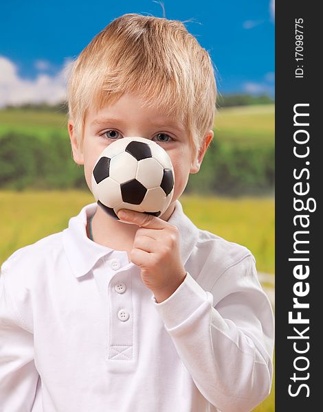Four year old boy holding football on natural background. Four year old boy holding football on natural background