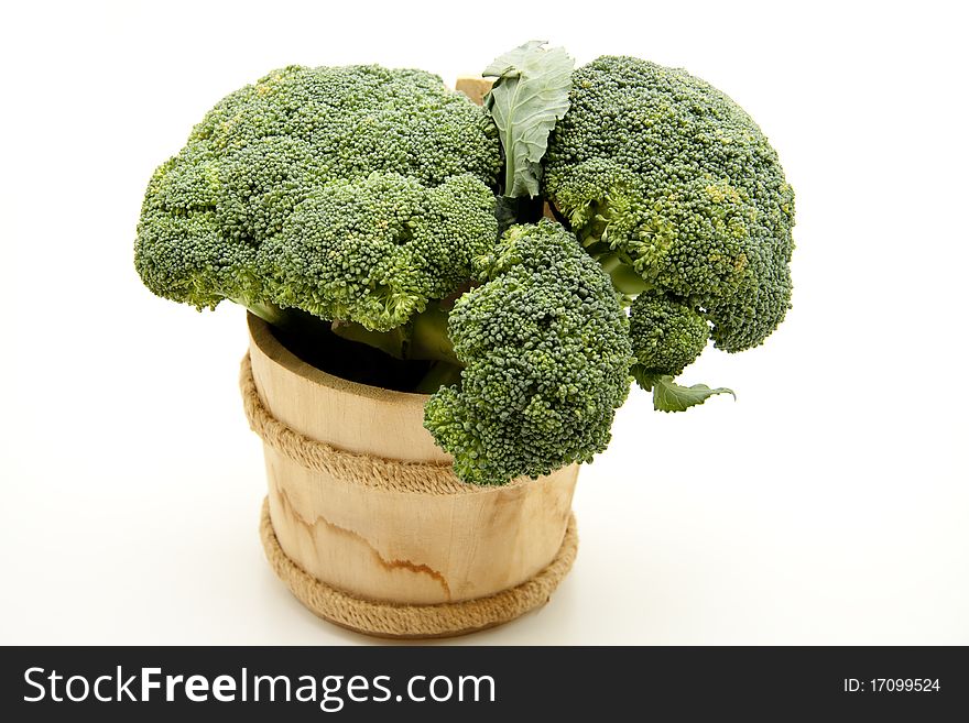Broccoli in wood receptacle onto white background
