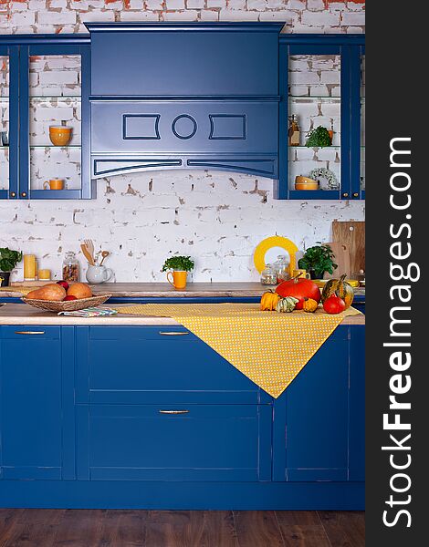 Modern Blue kitchen interior in loft style with furniture. Stylish Scandinavian cuisine in decor. wooden kitchen in rustic style. Empty wooden table and yellow spring decor in kitchen interior.