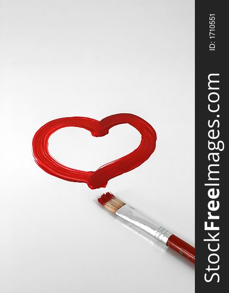 A red painted heart with paintbrush on white. A red painted heart with paintbrush on white