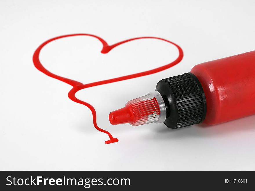 A red painted heart with paint bottle on white. A red painted heart with paint bottle on white