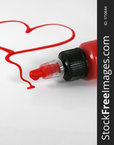 A red painted heart with paint bottle on white. A red painted heart with paint bottle on white