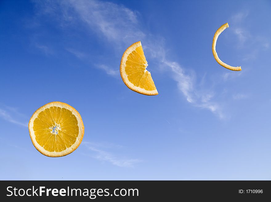 Orange slices at different stages of consumption on a blue sky background. Orange slices at different stages of consumption on a blue sky background
