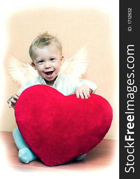 Laughing cute angel boy with big plush red heart. Vintage style card with copy space on the top right corner