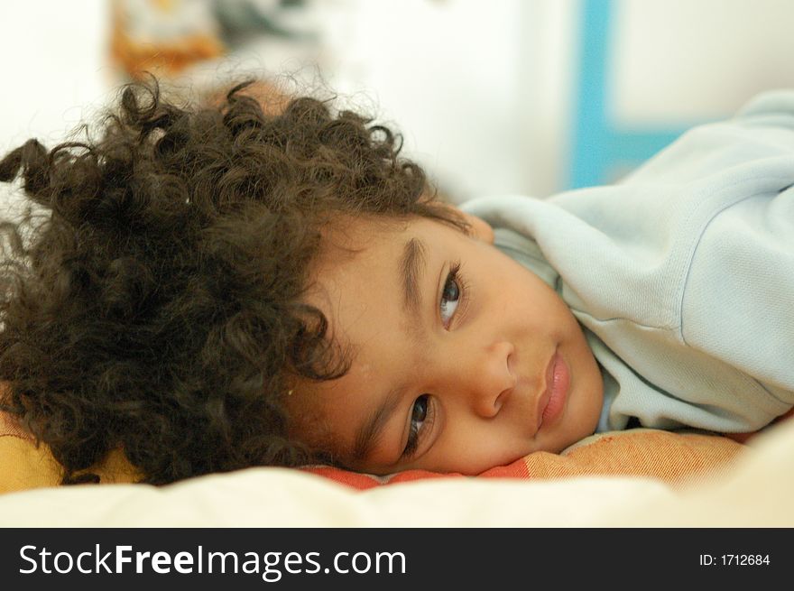 3 year old boy resting on a pillow. Horizontal close up viewing at camera right. 3 year old boy resting on a pillow. Horizontal close up viewing at camera right