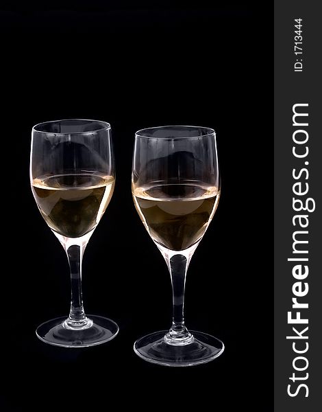 Two wine glasses with white wine (photographed on black background)