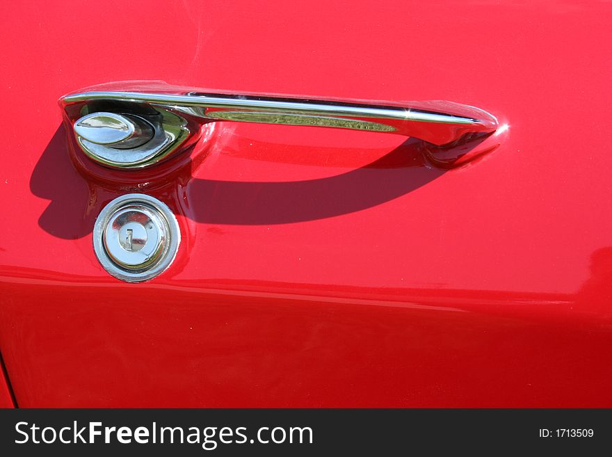 A red car door and handle. A red car door and handle.