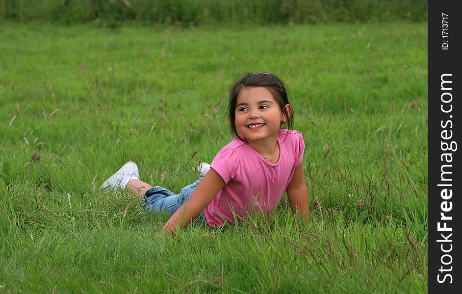 Little girl lying on the grass smiling. Little girl lying on the grass smiling