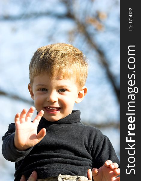 A little boy on father shoulder in the park