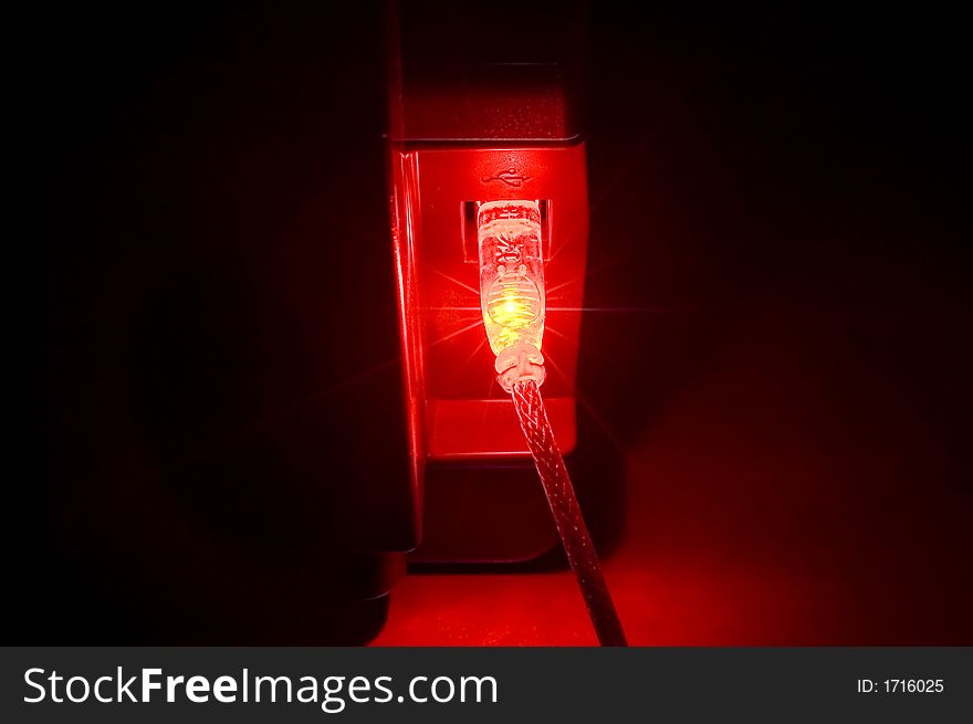 Red usb connector in a darkened room. Red usb connector in a darkened room