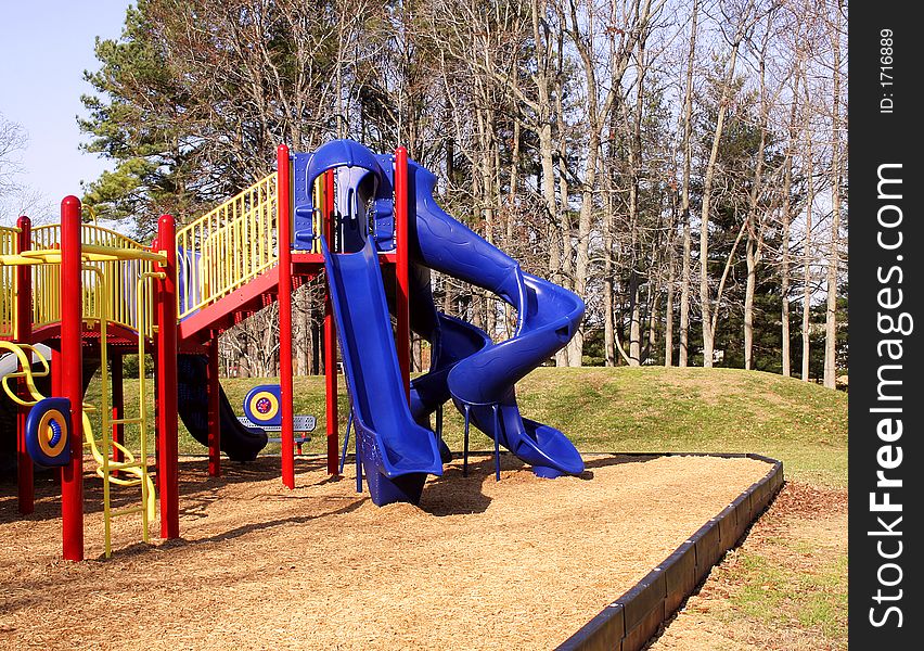 Color playground equipment at a park including a slide.