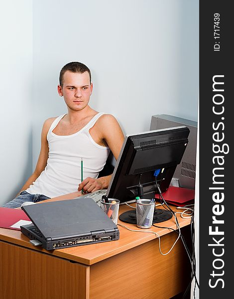 Young businessman works on a laptop computer in the modern office.