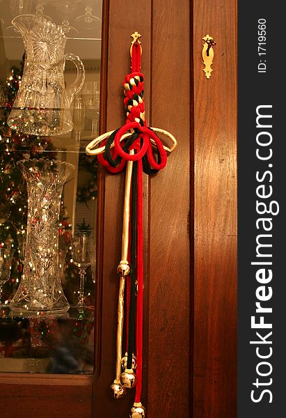 Decorative red and gold rope with bells hanging from antique furniture at Christmas. Decorative red and gold rope with bells hanging from antique furniture at Christmas