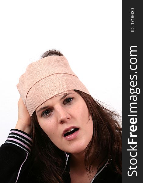 A young woman holds her head with bandage in pain. A young woman holds her head with bandage in pain.