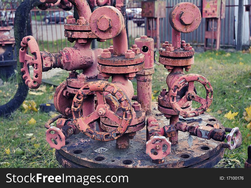 Complicated rusty industrial pipe structure with many different pipe-wheels; focus on front wheel. Complicated rusty industrial pipe structure with many different pipe-wheels; focus on front wheel