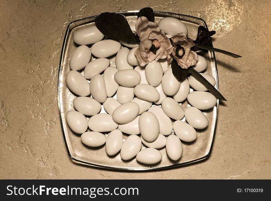 An old-looking shot of a plate filled with sugared almonds. An old-looking shot of a plate filled with sugared almonds