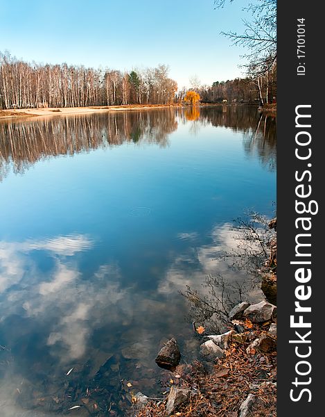 In pure lake the sky and trees are reflected. In pure lake the sky and trees are reflected