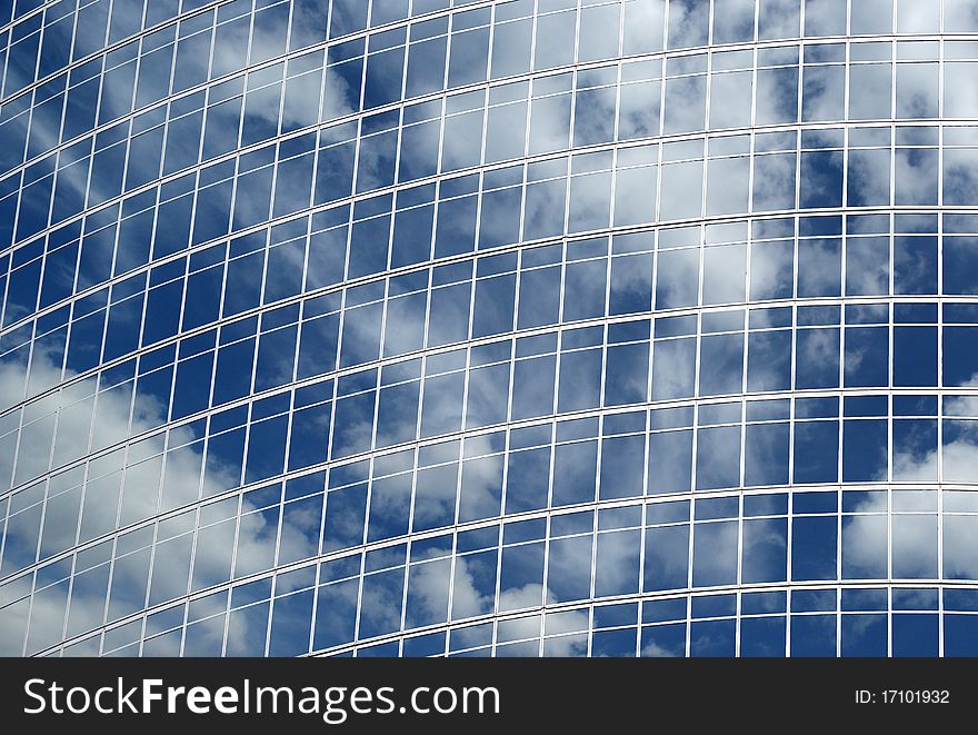 Reflection of a cloudy sky in glass wall