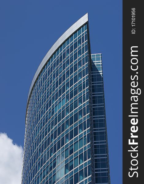 Reflection of a cloudy sky in glass wall of an office building