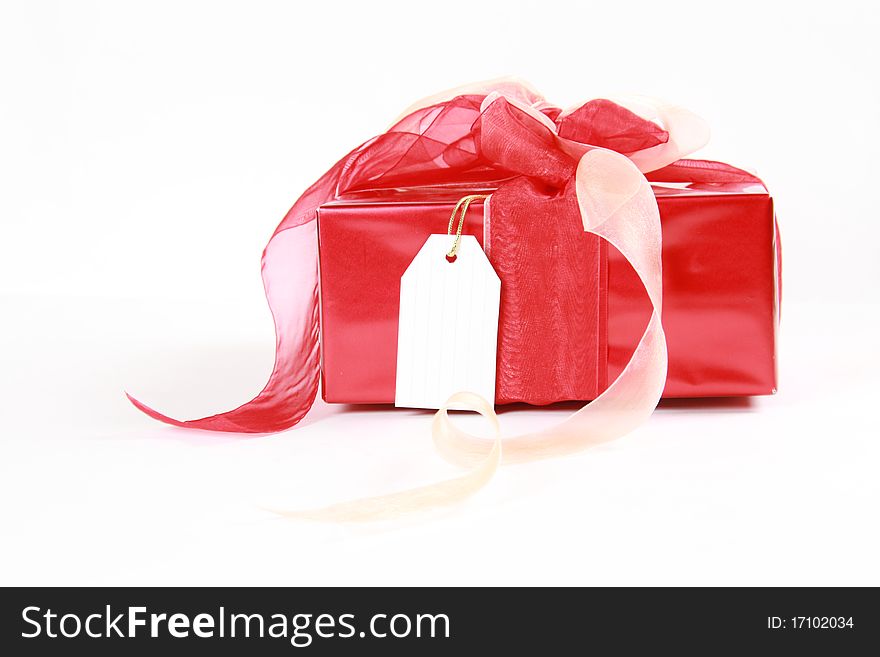 Red christmas gift box with blank tag isolated on white background