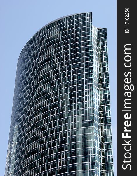 Reflection of a cloudy sky in glass wall of an office building