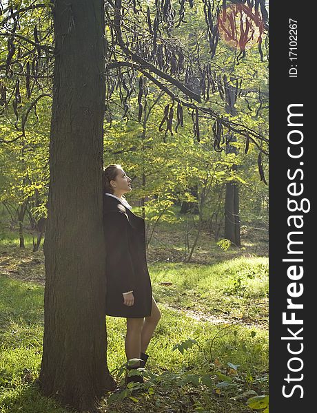 Girl stayning under the dark mysterious tree in the park. Girl stayning under the dark mysterious tree in the park