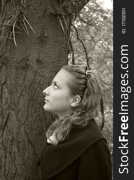 Innocent girl looks at dangerous needles on a tree
