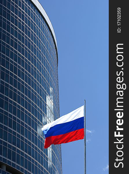 Russian flag on the background of the windows of office building