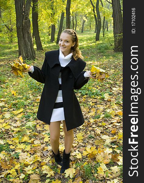 Happy young girl enjoying autumn in the park